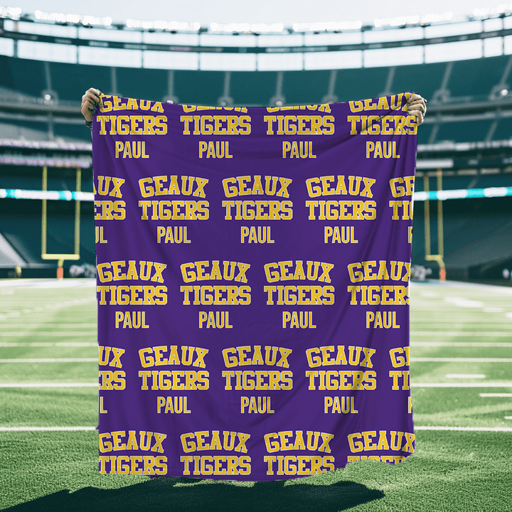 A personalized Blanket in Purple and Gold that says Geaux Tigers with a block font.